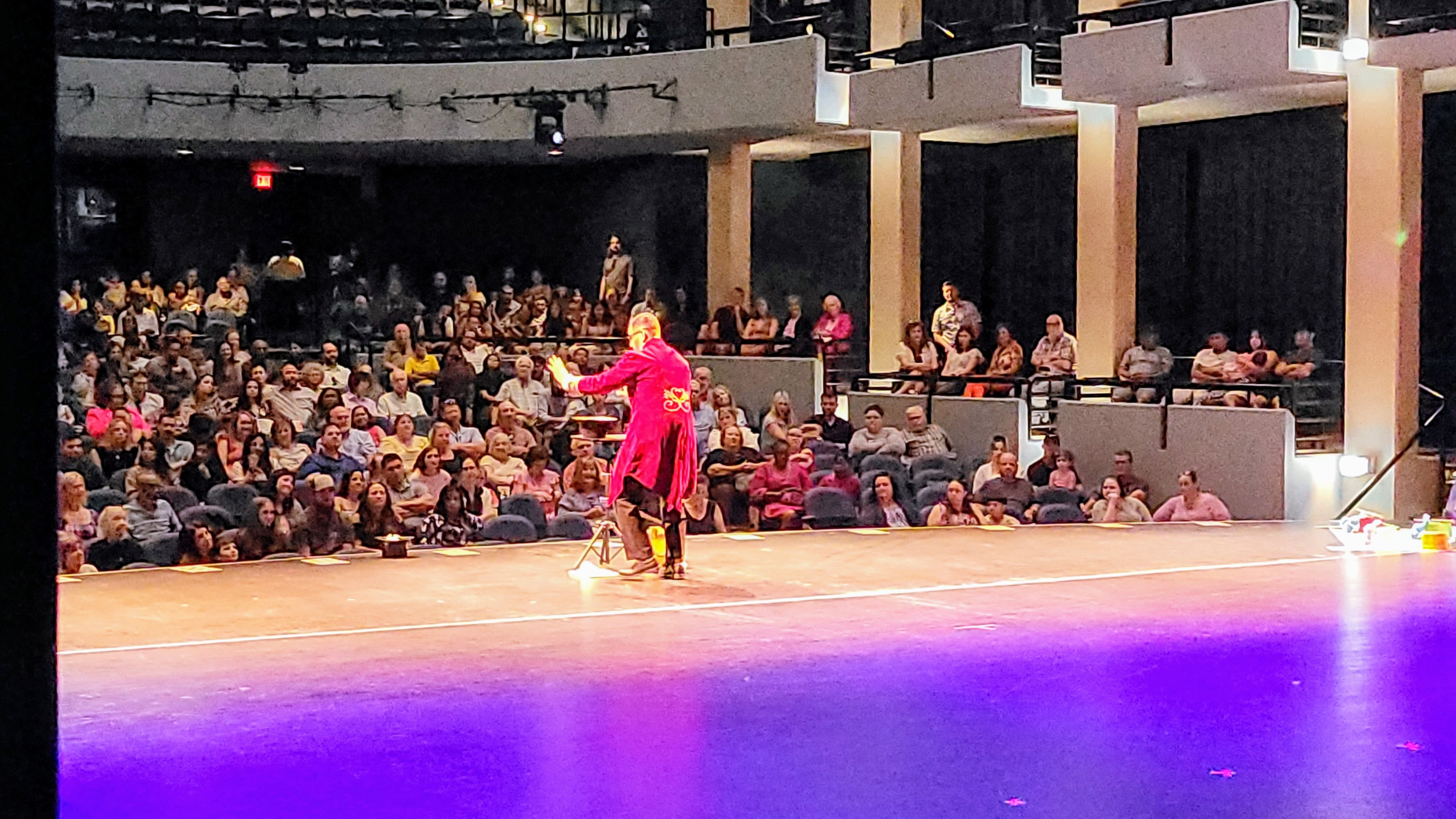 C. Magic performing on stage before a packed auditorium