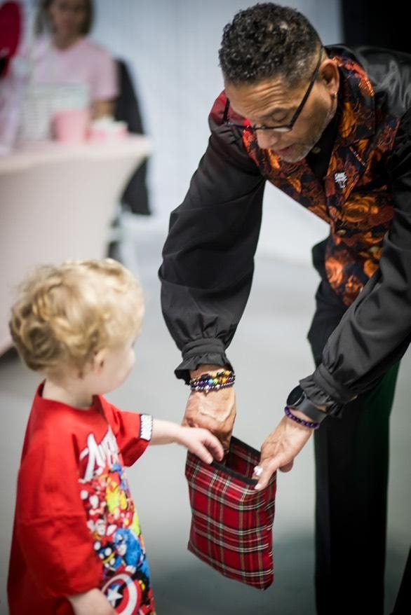 C. Magic performing magic trick with young child